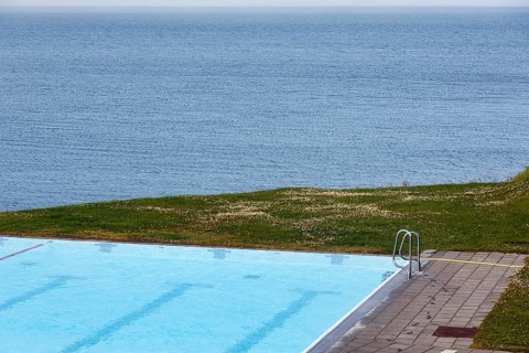 View from above of swimming pool by the sea, thermal bath, heated outdoor pool in Hofsos at the