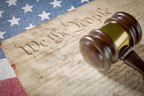United states constitution, gavel and american flag resting on table