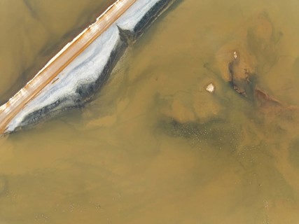 Salt road and Greater Flamingos (Phoenicopterus ruber) at the Walvis Bay Lagoon. Aerial view. Drone