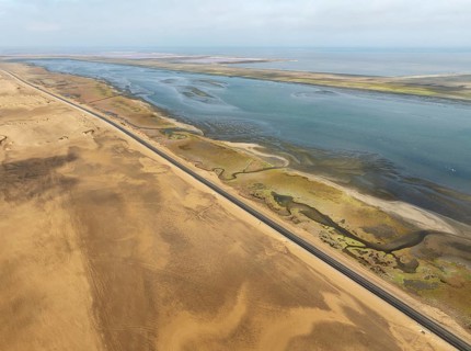The Walvis Bay Lagoon between Namib Desert and Atlantic Ocean. At low tide with scattered flamingos