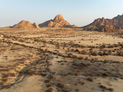 The isolated Spitzkoppe mountain (1728 m) majestically rises above the surrounding desert plains.