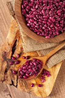 Red beans, laid out in a wooden bowl, on a chopping board, rustic style, covered with burlap, top