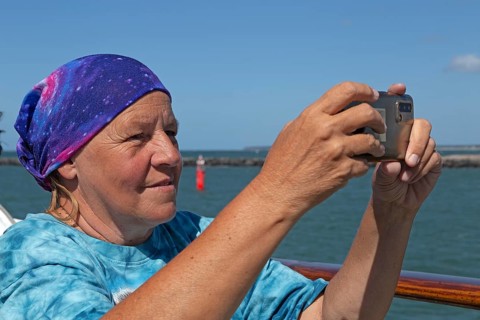 Elderly woman taking photos with smartphone, Warnemünde, Rostock, Mecklenburg-Western Pomerania,