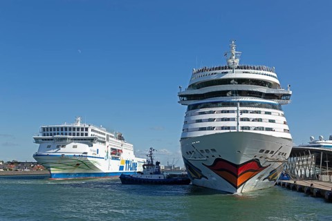 Cruise ship AIDA nova is pushed against the quay wall by tugboats, TT-Line ferry Nils Holgersson,