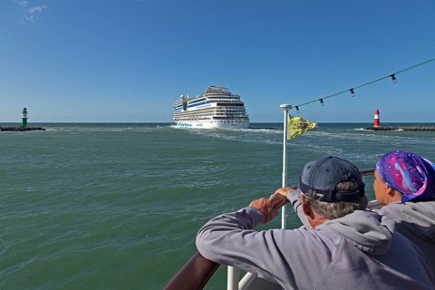 Cruise ship AIDA nova leaving, lighthouse, spectators, escort cruise, Warnow estuary, Warnemünde,
