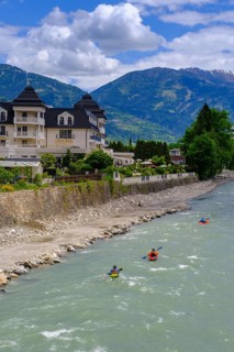 Kayakers in the river in front of the Grandhotel Lienz on the Isel, Lienz, East Tyrol, Austria