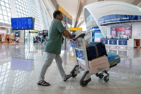 Airport man with luggage, Abu Dhabi, United Arab Emirates