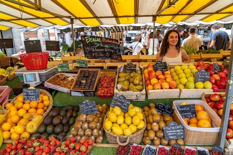 Vendor at her stall selling fruit at the market in La Rochelle, France