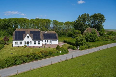 Typical Frisian house, photovoltaics on the roof, landscape on the dyke, Tammensiel, Pellworm