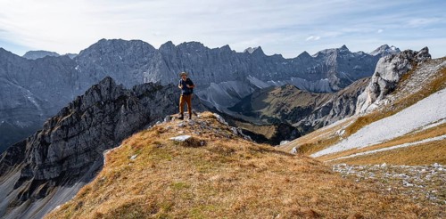 Mountaineers in front of a picturesque mountain landscape in autumn, view of the rocky ridge of the