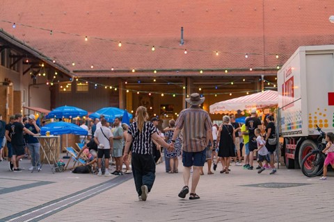 Lively scene at an evening event with many people and colourful lights, 950 years Weil der Stadt
