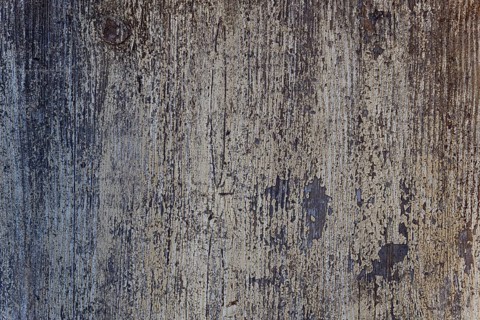 Een verouderen houten muur met afbladderende verf en een unieke textuur. De ruimte straalt een
