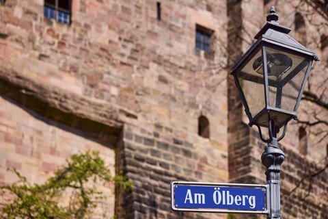 Street sign, street name Am Ã–lberg, lantern, castle wall, depth of field, Nuremberg, Middle