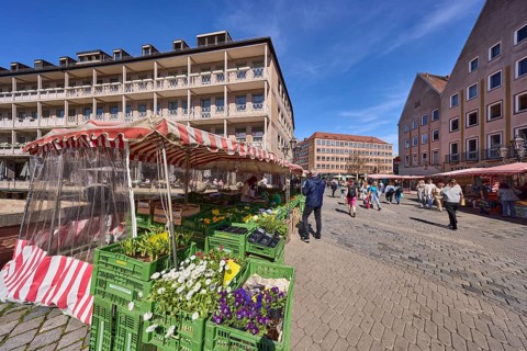Pedestrian zone, market, market stalls, flower stall, pedestrians as secondary motif, blue sky,