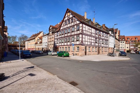 Old town, half-timbered house, general architecture, lantern, parking lane with vehicles, blue sky,