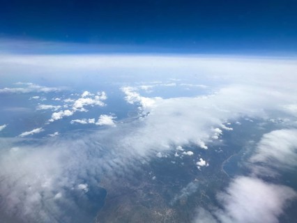 View from aeroplane at high altitude on white clouds Altostratus moving over coastal region of