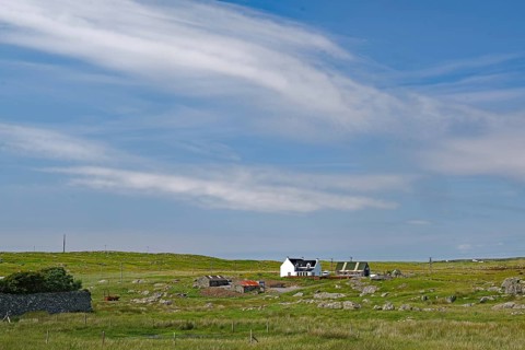 Rural area with a remote farmhouse under a wide blue sky, Outer Hebrides, South Uist, Scotland,