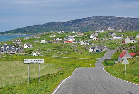 Small village in a hilly landscape with white houses and a main road, Outer Hebrides, Eriksay,