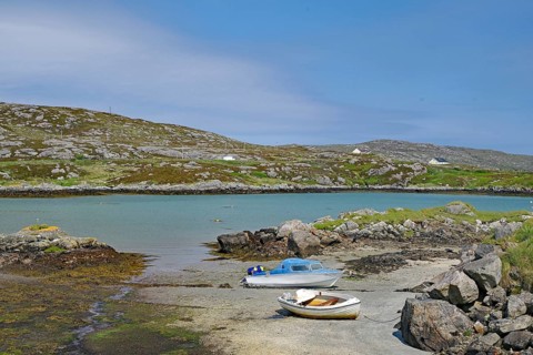 Two boats on a rocky shore in a quiet bay under a clear sky in front of hills, Idyll, Outer
