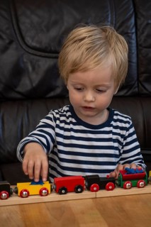 JBlond boy, 2 years old, playing with toy train in Ystad, SkÃ¥ne County, Sweden, Scandinavia