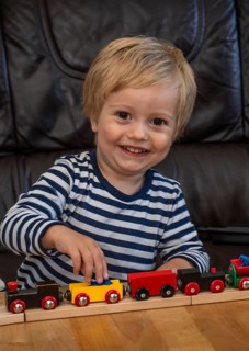 Blond boy, 2 years old, playing with toy train in Ystad, SkÃ¥ne County, Sweden, Scandinavia