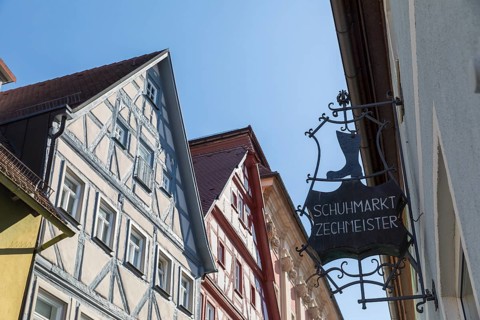 Advertising sign of the Zechmeister shoe market, behind it the half-timbered gables of the old