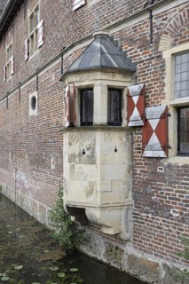 Medieval bay window on a brick wall with red shutters and moat, Raesfeld Castle, MÃ¼nsterland,