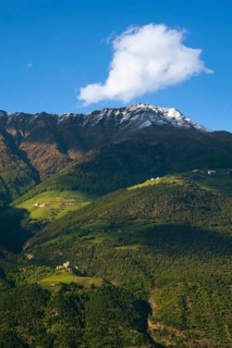 View of the Sonnenberg with Annenberg Castle and the farms above in the evening light, Dolomites,
