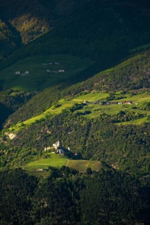 View of the Sonnenberg with Annenberg Castle and the farms above in the evening light, Dolomites,