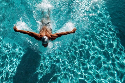Muscular young swimmer swims in the lane. Concept of having purpose and determination and reaching