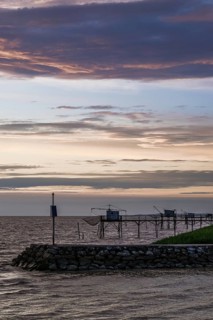 Sunset over Fishing huts over Gironde Estuary, Braud-et-Saint-Louis, France