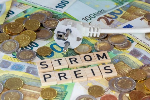 Symbolic image of electricity costs: electricity plug with euro banknotes and euro coins, with the