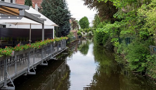 River with adjoining terrace and flowers, surrounded by green vegetation, Borken-Gemen,