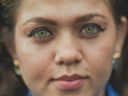 Close up of Latin American girl face looking and smiling at the camera. Portrait of attractive
