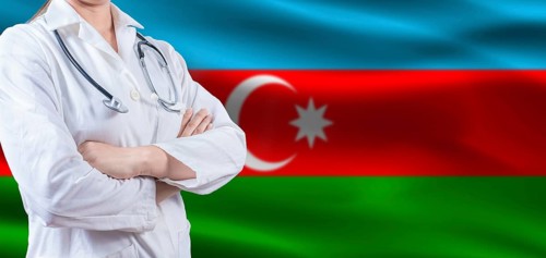 Doctor with crossed arms on Azerbaijan flag. Azerbaijan health and care concept. Female doctor on