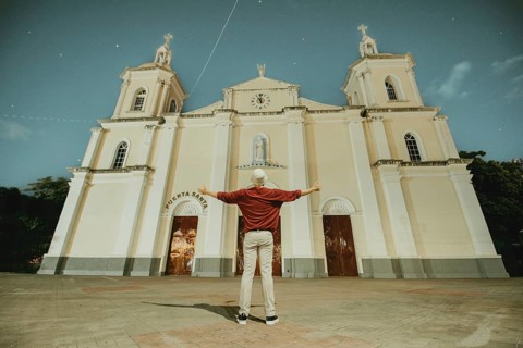 Tourist with open arms at the Esteli Cathedral, Nicaragua. Man with open arms at the Esteli