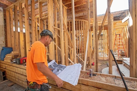 Detroit, Michigan - Jay Newcomb III looks over architectural plans as workers rehab a long-vacant