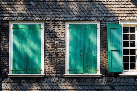 Weathered green shutters on a slate-clad house in Wuppertal, Germany