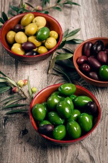 A mixture of olives, varieties of chalkidiki, Verdi giganti and Kalamata, in a bowl, top view, no