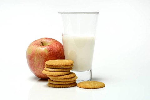 Cracker with glass of milk and apple