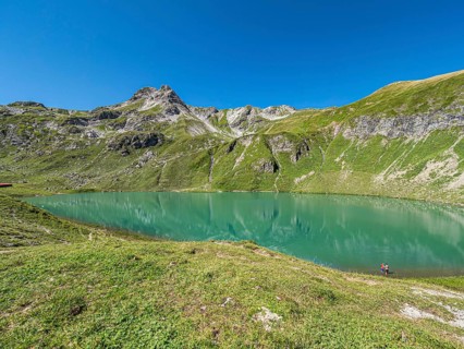 Hiker at lake Engeratsgundsee, mountain range between Oberstdorf and Bad Hindelang, Allgaeu,
