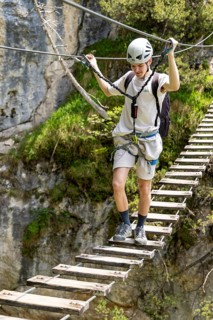 Mountaineer climbing over a suspension bridge on the Isidor via ferrata, GrÃ¼nstein, Schönau am