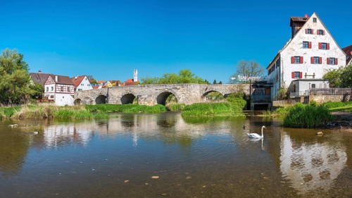View over the river Wörnitz to the old town with the medieval stone bridge and the Herz Jesu