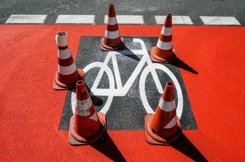 Warning cones standing on a cycle path sprayed with a stencil Symbol on a newly built cycle path,