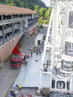Construction of a Ferris wheel near a road with fire engines and people, fire brigade exercise for