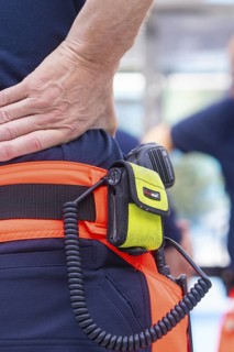 Close-up of fire brigade equipment with radio and firefighter in uniform, fire brigade exercise for