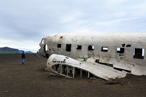 Tourist photographing aircraft wreckage, US Navy Douglas DC-3 transport plane, Sander, volcanic