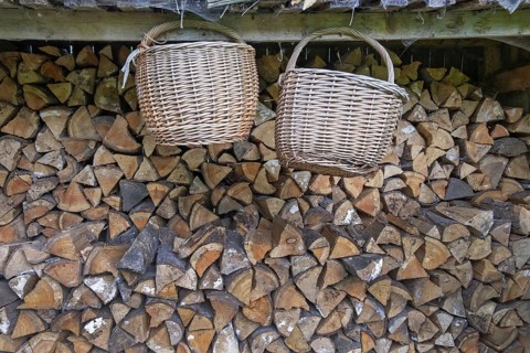 Two baskets hanging in front of a pile of wood, Germany