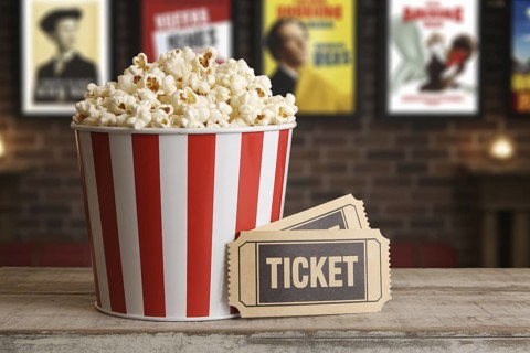 Red and white striped popcorn bucket with vintage movie tickets on wooden surface. Generative ai,