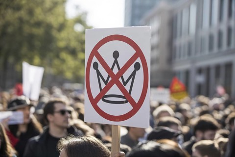 Close-up of protest sign with crossed-out crown. No kings Demonstration in progress. Generative AI,